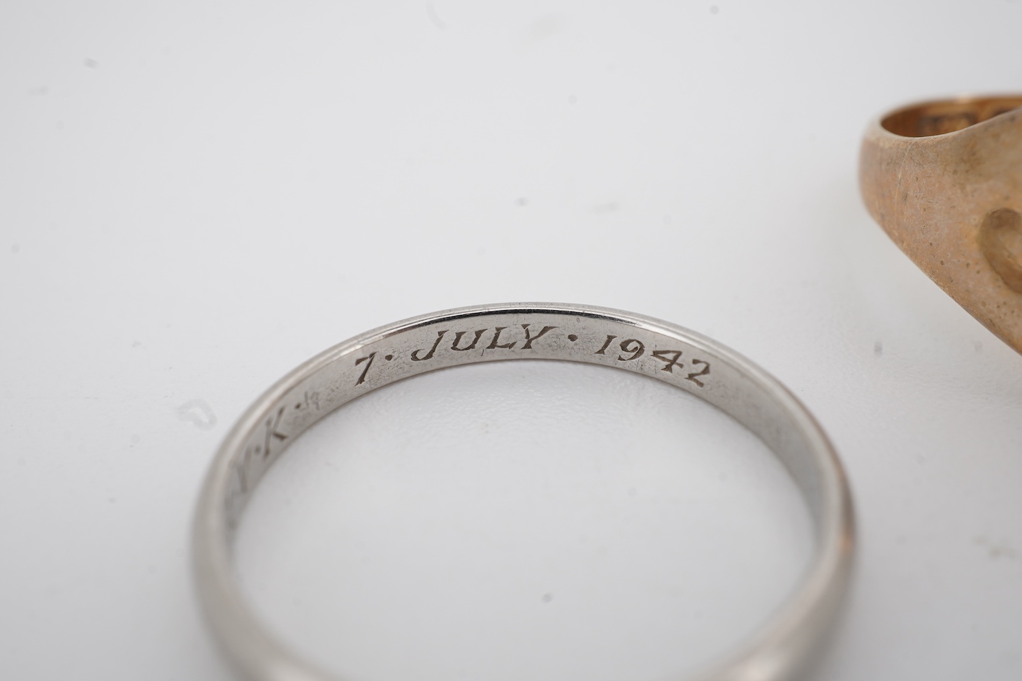 A 1940's platinum wedding band, with engraved inscription, size M, 2.3 grams together with a 9ct signet ring and a yellow metal wedding band.